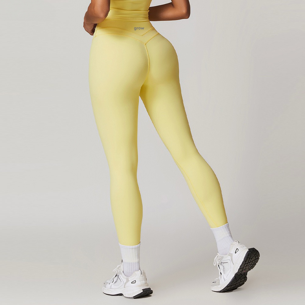 Person wearing yellow leggings and white sneakers on a plain background